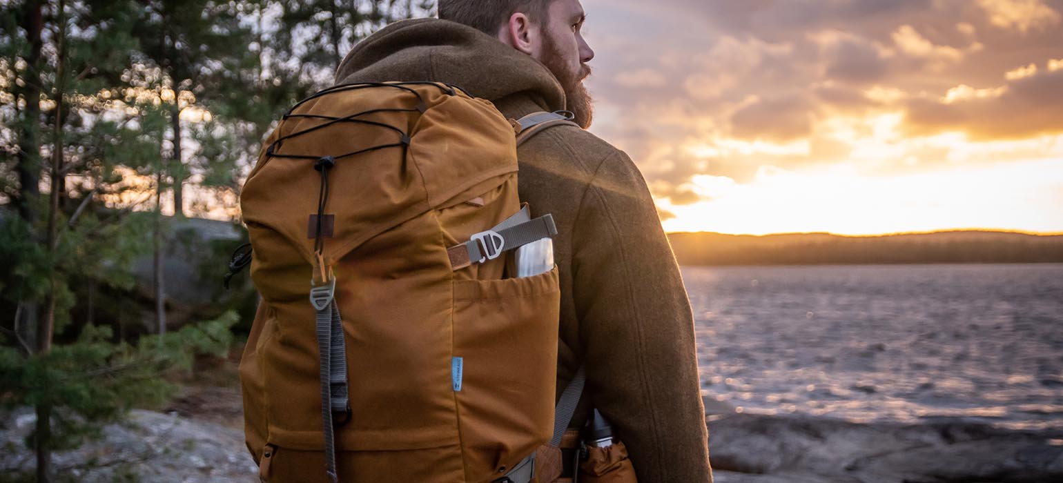 Mann mit Rucksack am See